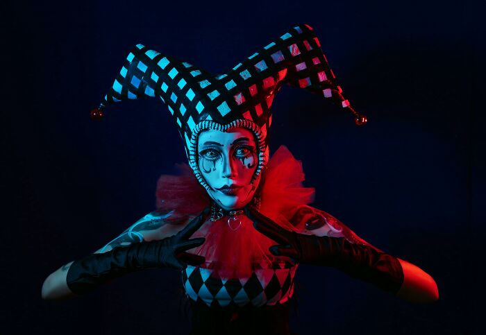 Person dressed as a jester with a checkered hat and dramatic makeup, illustrating occupations that evolved from heroic to hilarious.