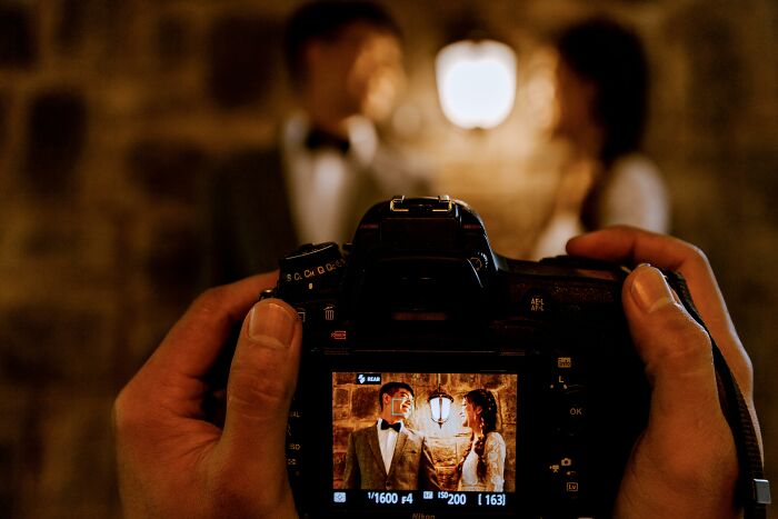 Camera capturing a couple in a comedic wedding pose.