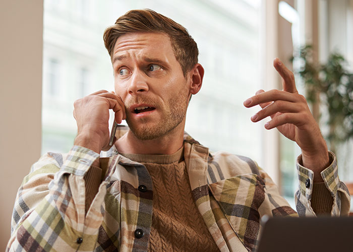 Man in plaid shirt talking on the phone, looking concerned about placing mom in a care facility before holidays. Man in plaid shirt talking on the phone, looking concerned about placing mom in a care facility before holidays.