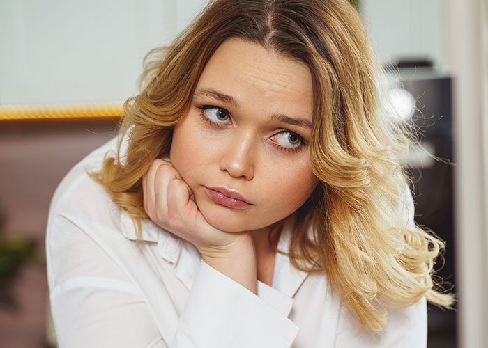 A woman in a white shirt looks thoughtful, possibly reflecting on Thanksgiving dish concerns. A woman in a white shirt looks thoughtful, possibly reflecting on Thanksgiving dish concerns.