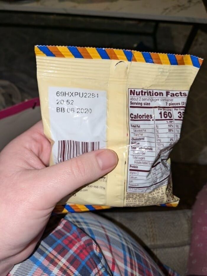 Expired snack being held, showing a best before date from 2020 on the packaging, related to Secret Santa gift. Expired snack being held, showing a best before date from 2020 on the packaging, related to Secret Santa gift.