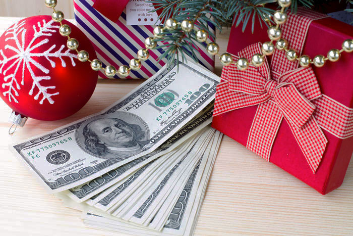 Dollar bills beside festive decorations and a gift box, symbolizing clearing debt during holiday season. Dollar bills beside festive decorations and a gift box, symbolizing clearing debt during holiday season.