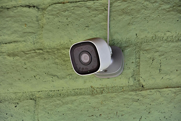 Security camera mounted on a green wall, capturing a peaceful life setting until a stalker reemerges. Security camera mounted on a green wall, capturing a peaceful life setting until a stalker reemerges.