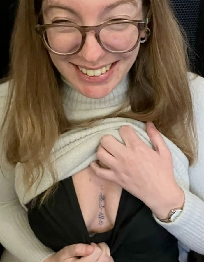 Smiling woman showing a semi-permanent tattoo under her shirt. Smiling woman showing a semi-permanent tattoo under her shirt.