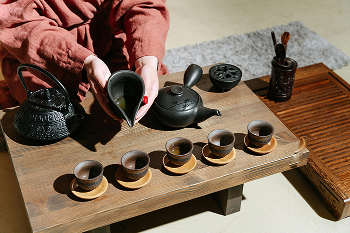 Tea ceremony setup with traditional teaware on a wooden table, showcasing cultural traditions. Tea ceremony setup with traditional teaware on a wooden table, showcasing cultural traditions.