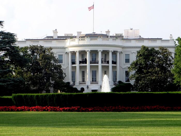 The White House stands majestically with the American flag flying, symbolizing historical occupations.