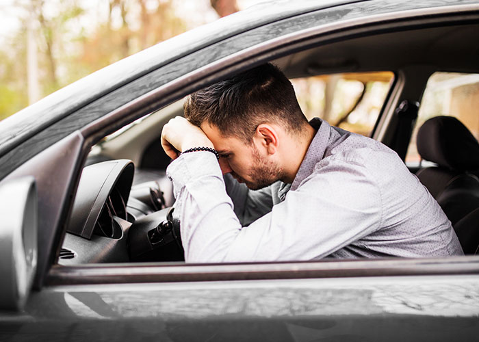 Man in car looking distressed, pondering public proposal situation. Man in car looking distressed, pondering public proposal situation.