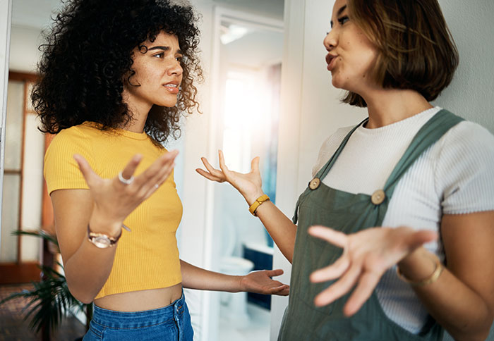Two women having a heated discussion at home, expressing frustration and disagreement. Two women having a heated discussion at home, expressing frustration and disagreement.