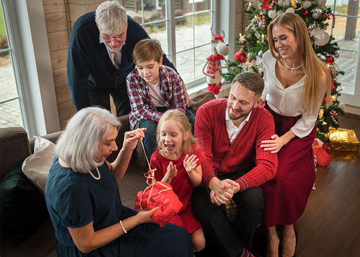 Family gathering around a Christmas tree, exchanging gifts and enjoying holiday moments together. Family gathering around a Christmas tree, exchanging gifts and enjoying holiday moments together.