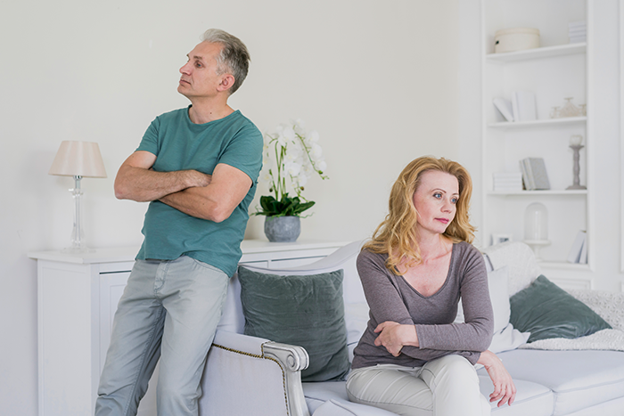 Upset couple sitting apart, highlighting a tense family situation regarding wedding plans and children. Upset couple sitting apart, highlighting a tense family situation regarding wedding plans and children.