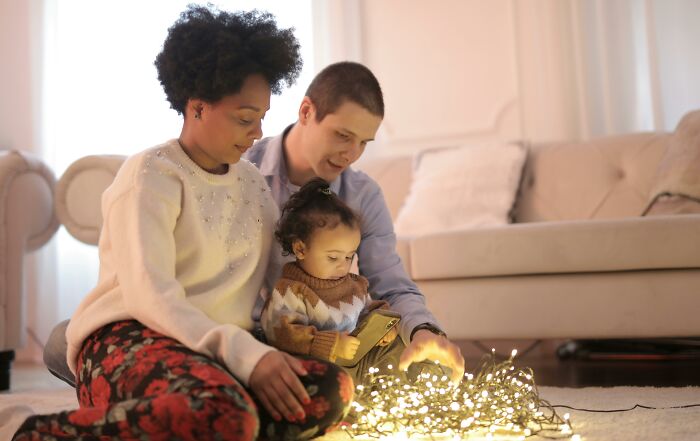 Family sitting together, focused on lights, creating a warm atmosphere in the living room. Family sitting together, focused on lights, creating a warm atmosphere in the living room.