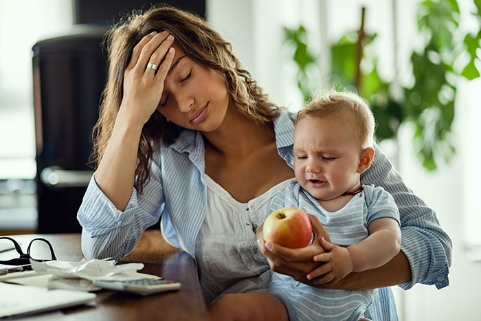 Stressed woman with baby, pressured by family for childcare at wedding, looks overwhelmed. Stressed woman with baby, pressured by family for childcare at wedding, looks overwhelmed.