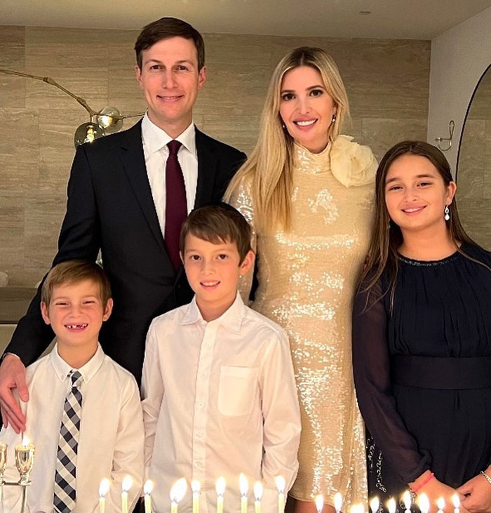Family dressed elegantly, gathered around lit candles for a celebration, emphasizing elegance and class in their attire. Family dressed elegantly, gathered around lit candles for a celebration, emphasizing elegance and class in their attire.