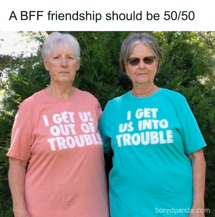 Two women in humorous shirts; one reads "I get us out of trouble," the other "I get us into trouble." Moms behaving badly theme.
