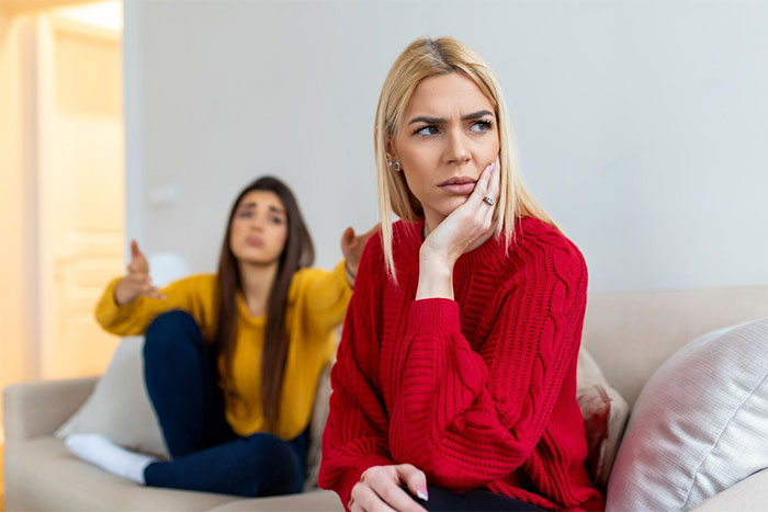 Two women on a couch; one looking upset, highlighting demands about a handmade gift. Two women on a couch; one looking upset, highlighting demands about a handmade gift.