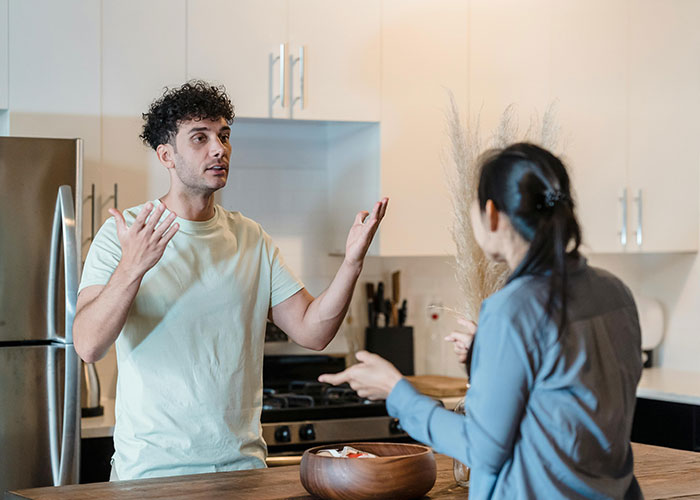 Vegetarian wife upset with husband in kitchen over meal prep disagreement. Vegetarian wife upset with husband in kitchen over meal prep disagreement.