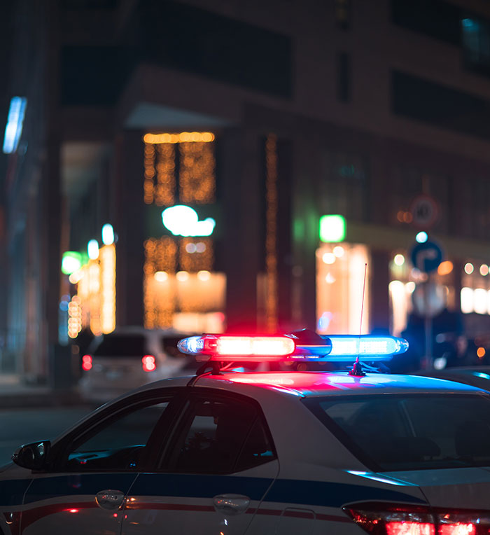 Police car with flashing lights outside a hotel at night. Police car with flashing lights outside a hotel at night.