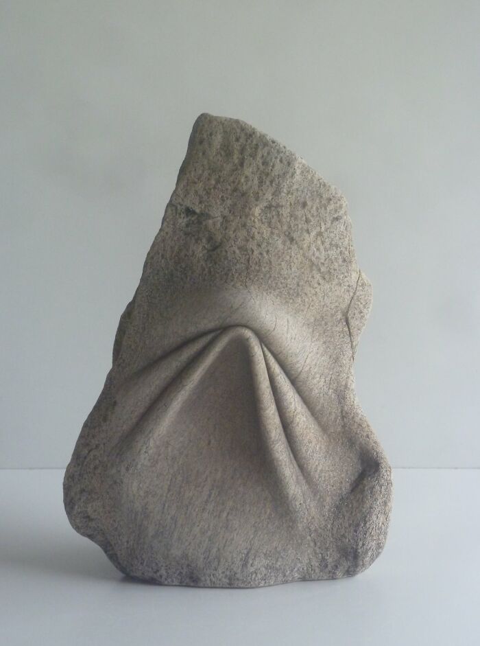 Stone sculpture resembling soft, folded fabric, showcasing intricate artistry and defying the laws of physics.