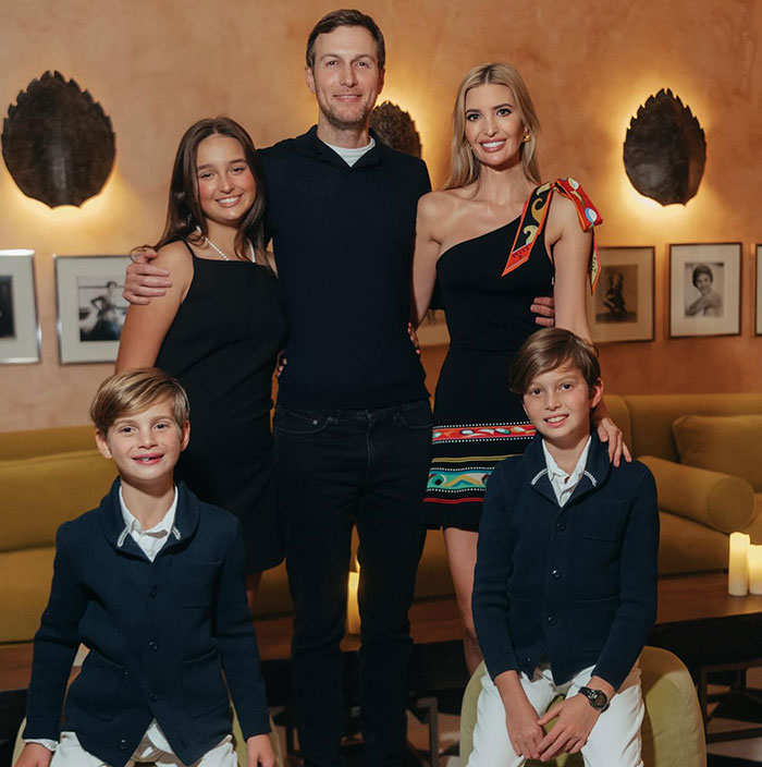 Family posing together in a living room; focus on elegance and class in their attire. Family posing together in a living room; focus on elegance and class in their attire.
