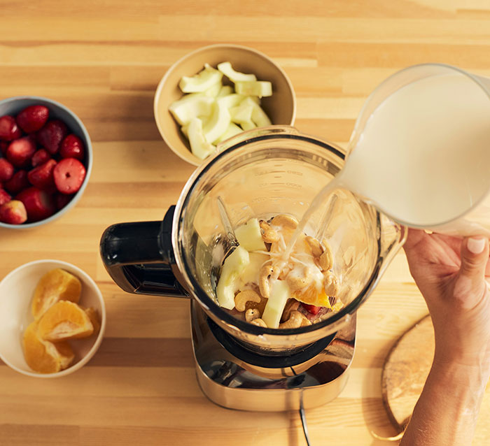 Milkshake preparation using blender with fruits and milk. Milkshake preparation using blender with fruits and milk.