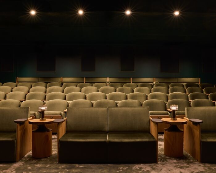 Elegant interior design featuring a stylish, modern theater with plush seating and ambient lighting.