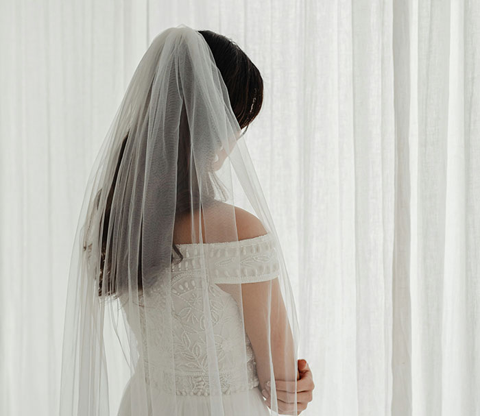 Bride in wedding dress and veil, symbolizing elaborate marriage scam involving influencer. Bride in wedding dress and veil, symbolizing elaborate marriage scam involving influencer.