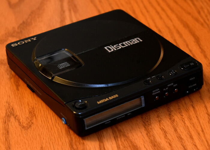 2000s teens nostalgia: Sony Discman with Mega Bass on a wooden table.