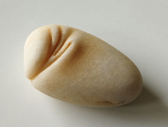 Smooth stone sculpture with soft, realistic folds, defying physics.