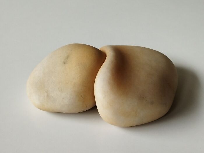 Two smooth stones with a soft appearance, showcasing sculptures that defy physics.