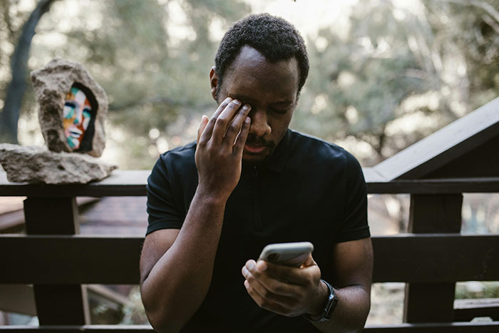 Man looking stressed while reading something on his phone, outdoors. Man looking stressed while reading something on his phone, outdoors.
