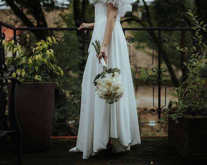 Bride in wedding dress holding bouquet, standing by a railing, representing a wedding scam. Bride in wedding dress holding bouquet, standing by a railing, representing a wedding scam.