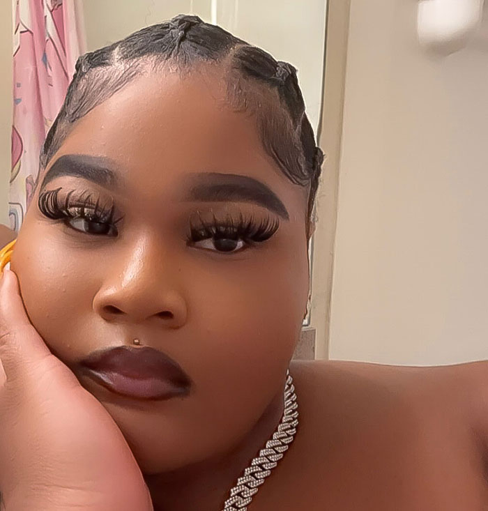 Plus-size woman with braided hair and diamond necklace posing indoors. Plus-size woman with braided hair and diamond necklace posing indoors.