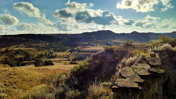 Scenic landscape of rolling hills and valleys under a sky with clouds, showcasing amazing views in the states.