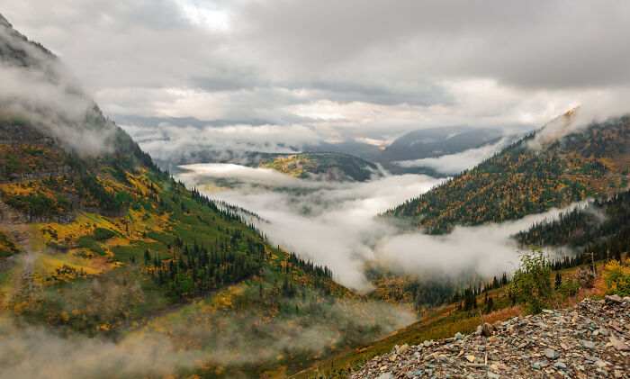 Mountain landscape with amazing views, featuring misty clouds over green valleys and hills.