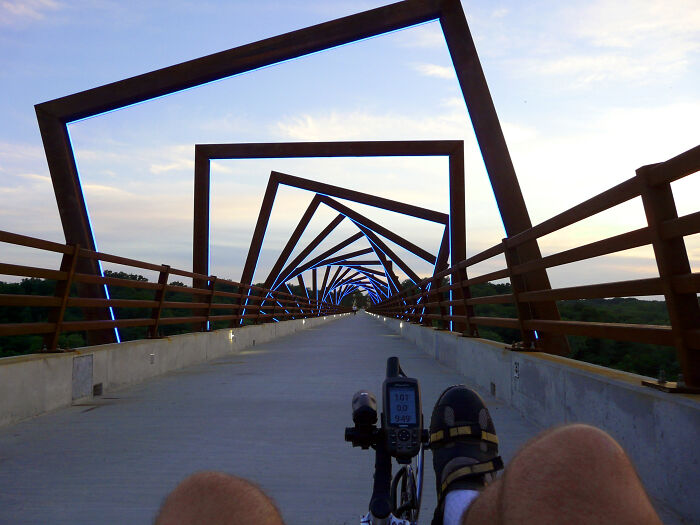 Amazing views from a cyclist's perspective on a modern bridge at sunset.