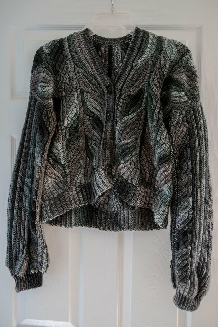 Gray cable knit crochet cardigan with buttons, showcasing intricate patterns by a proud crochet enthusiast.