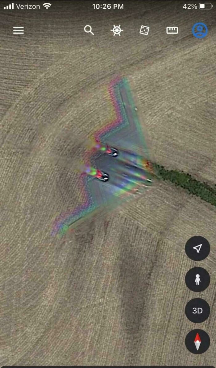 Aerial view of a unique rainbow trail effect behind a jet, showcasing fascinating visual patterns on a field.