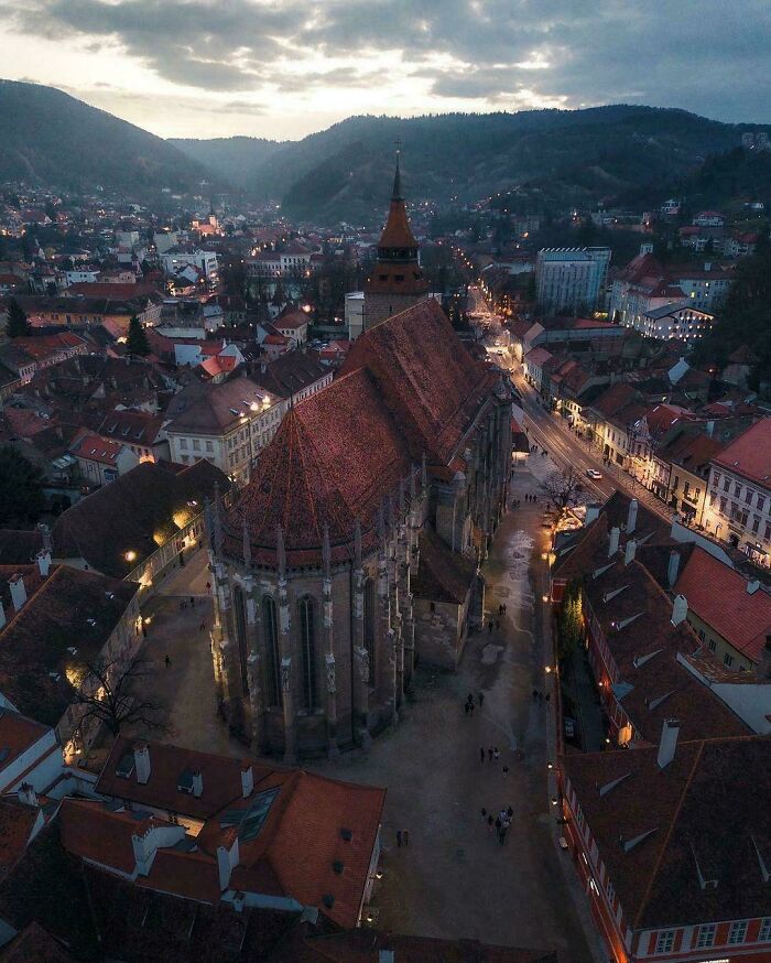 Aerial view of a historic church framed by a quaint cityscape at dusk, showcasing fascinating architecture and scenery.