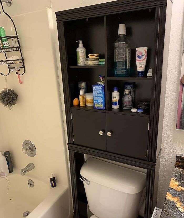 Bathroom storage cabinet installed above toilet with toiletries and cleaning products, showcasing low-lift high-impact improvements.