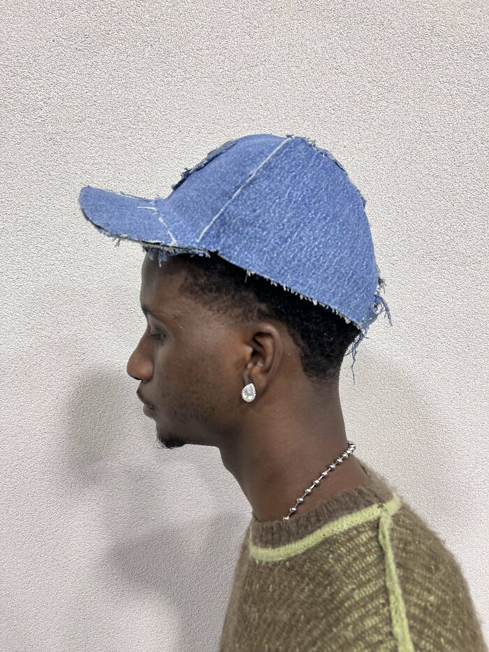 Person wearing a DIY denim cap, showcasing a creative project idea.
