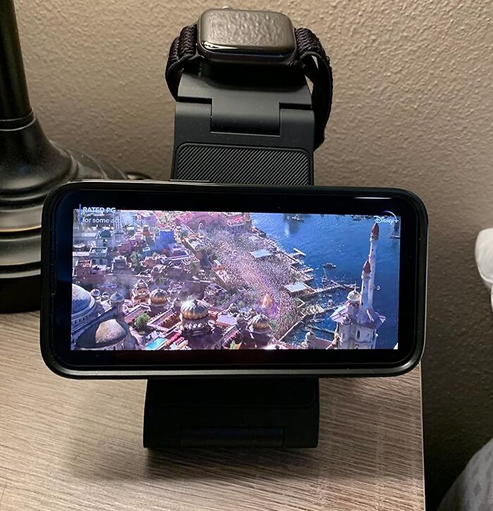 Smartwatch and phone on a stand, displaying a cityscape, perfect for travel planning.
