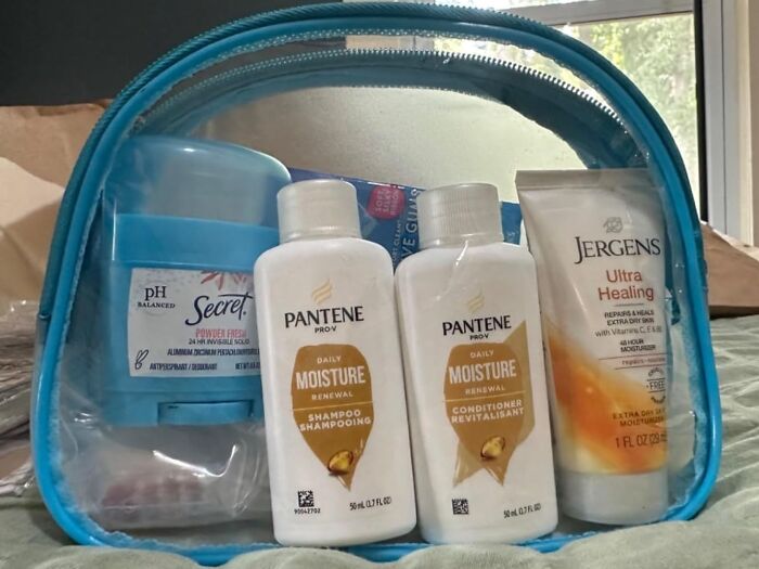 Travel essentials in a clear toiletry bag, including shampoo, conditioner, deodorant, and lotion for a travel-ready year.