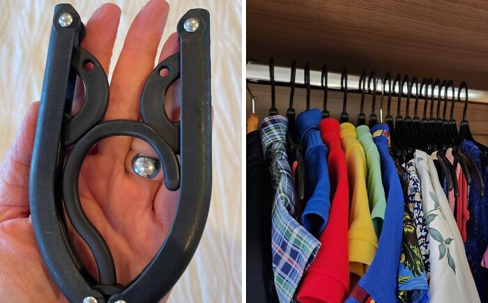 Travel essentials: a magnetic clasp in hand. Neatly organized clothes on black hangers in a wooden wardrobe.