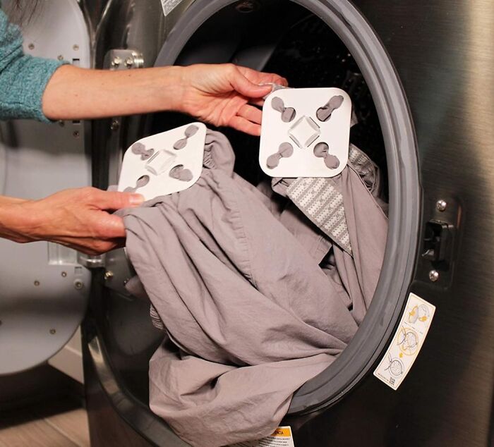 Laundry hack in action: using a dryer sheet to simplify clothes drying.