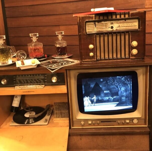 Retro finds: Vintage TV, radio, and record player with decanters on wood shelf, evoking nostalgia for good old days.