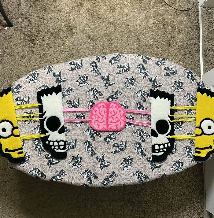 DIY project rug with cartoon design featuring two yellow faces and a pink brain on a patterned background.