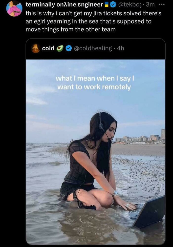 Woman working remotely on a laptop while sitting in shallow ocean water wearing a headset near the beach.