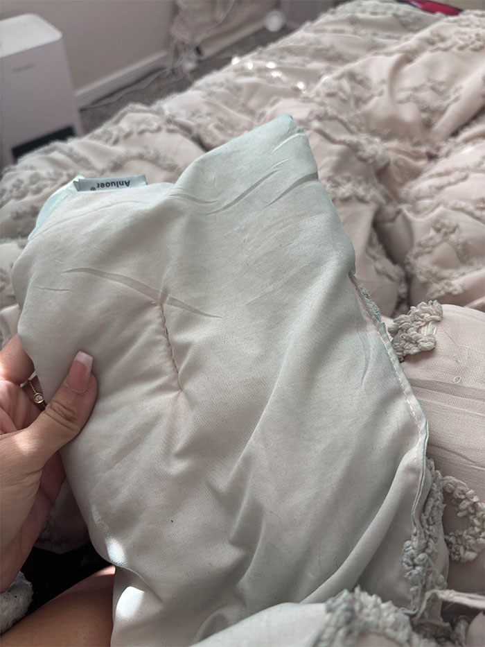 Woman holding a white blanket with visible stains, discussed in online user jokes about a mistress. Woman holding a white blanket with visible stains, discussed in online user jokes about a mistress.