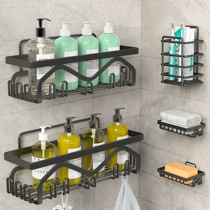 Black metal bathroom shelves with bath products, soap, toothbrushes, and towels mounted on tiled wall for bathroom improvements.