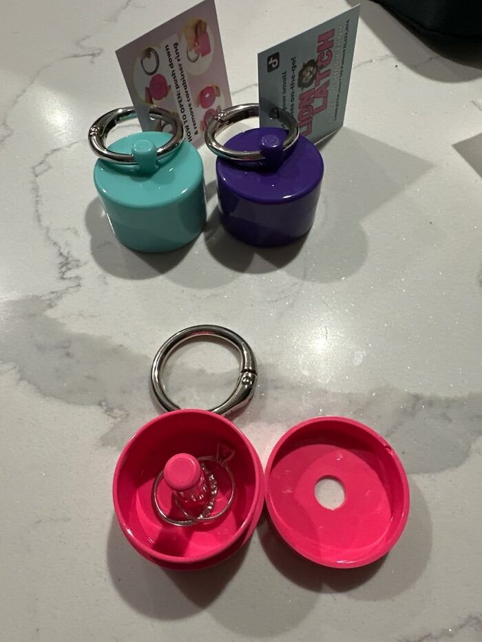 Travel essentials: Three colorful travel containers with keychain rings on a marble surface.